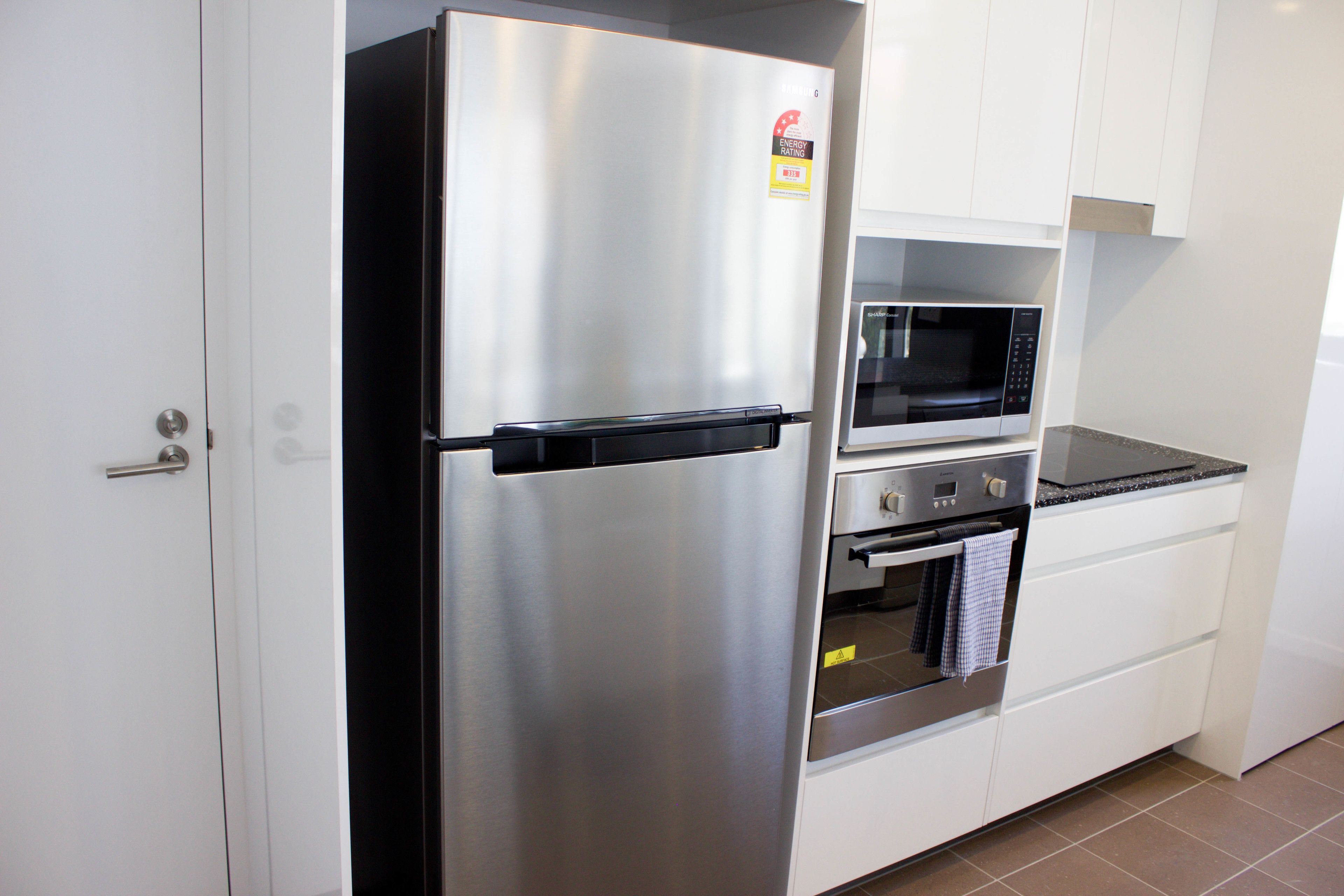 Una cocina moderna con un refrigerador de acero inoxidable, un microondas y un horno.