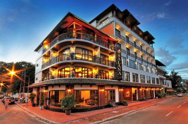 A multi-story hotel with balconies, outdoor seating, and a well-lit facade. - Salana Boutique Hotel (Vientiane)