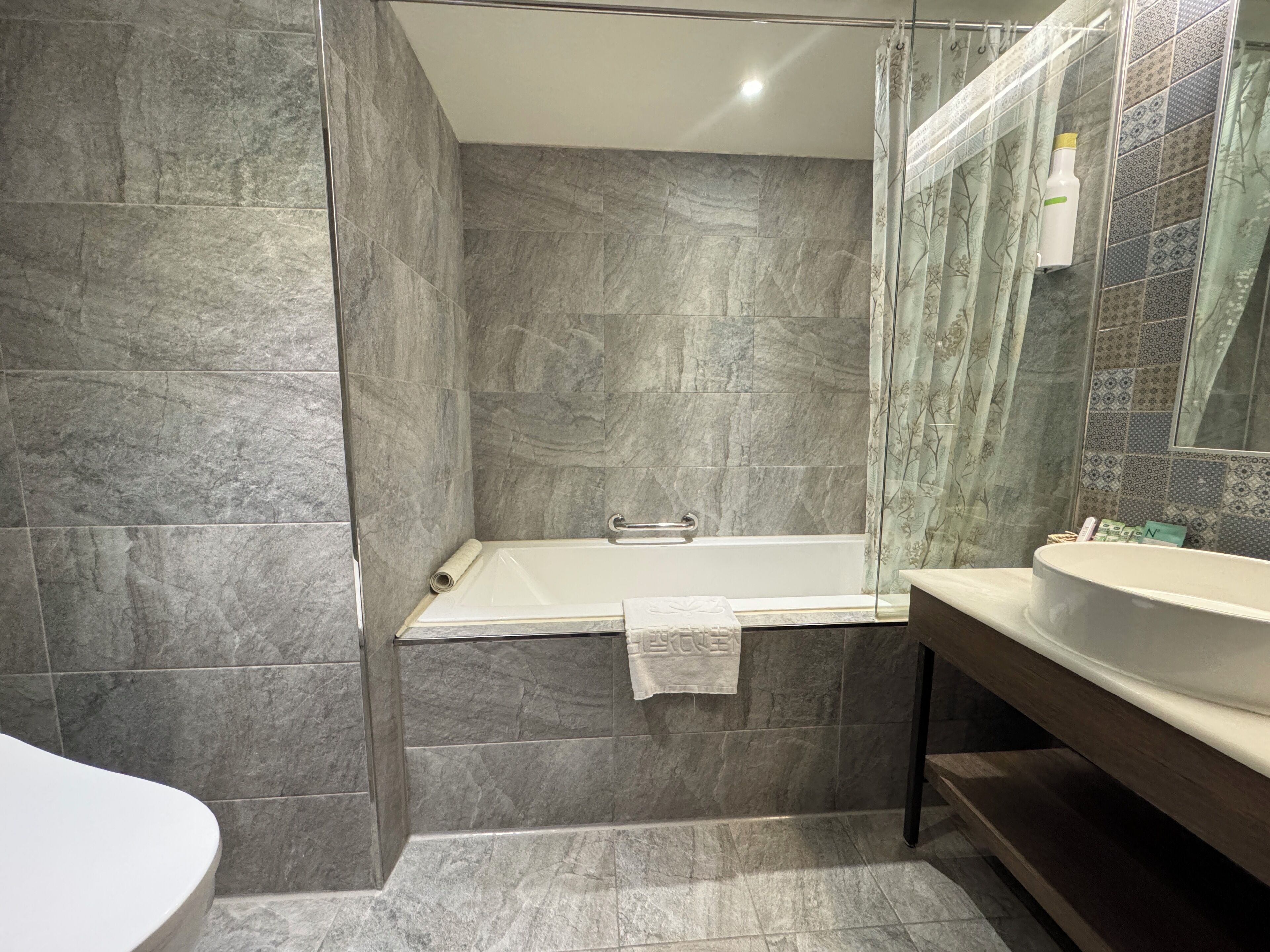 A modern bathroom with a freestanding bathtub, a glass shower enclosure, and a vanity with a mirror.
