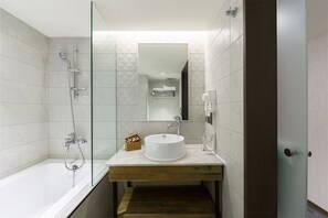 Standaard vierpersoonskamer | Badkamer | Een haardroger, pantoffels, handdoeken, zeep