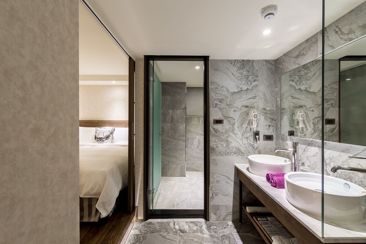 Un baño moderno con dos lavamanos, un espejo grande y una zona de ducha.