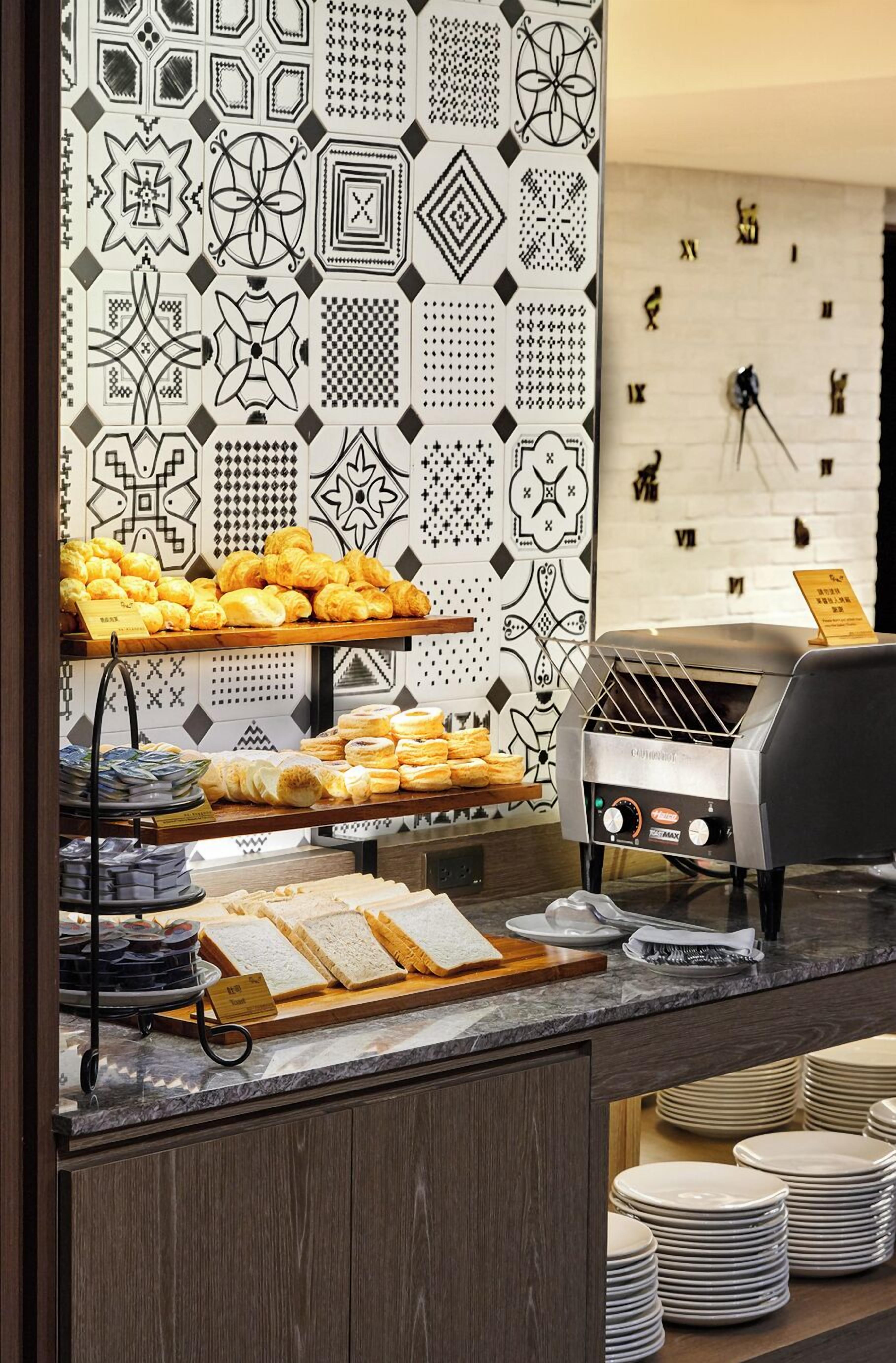 A breakfast buffet with pastries, bread, and a coffee machine.