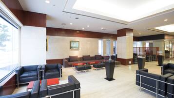 A modern lobby with leather seating, a reception desk, and large windows.