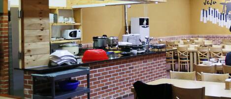 Un restaurante con pared de ladrillo, muebles de madera y una barra con equipo de cocina.