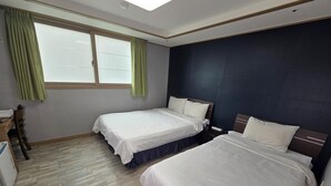 A hotel room with two beds, a desk, and a chair.