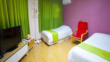 A hotel room with two beds, a TV, a chair, and a bedside table.