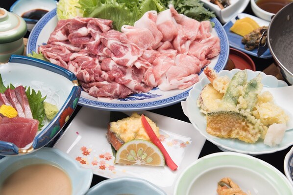 A table with various dishes including sashimi, tempura, and other Japanese cuisine. - Hakuba Royal Hotel (Hakuba)