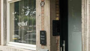Un bâtiment doté d’une grande fenêtre sur laquelle est inscrit le nom « vyrohof » et d’une porte portant l’inscription « ENTRÉE DE L’HÔTEL ».