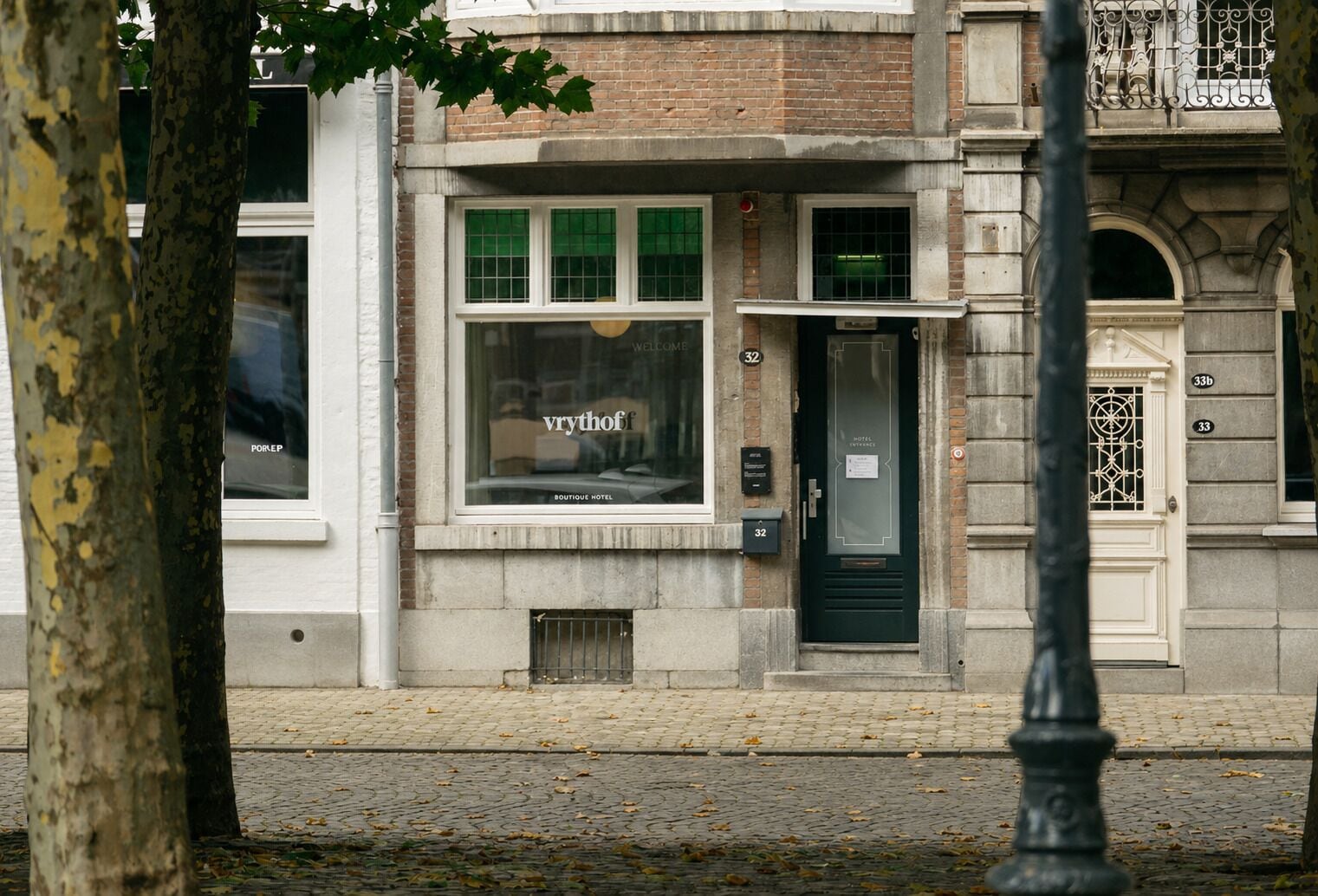 A building with a boutique hotel sign, a door with a window, and a number 32 on the wall.