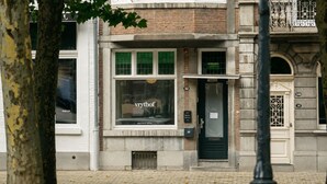 A building with a boutique hotel sign, a door with a window, and a number 32 on the wall. -  Hotel Vrythof - just a room - digital key by email or SMS (Maastricht)