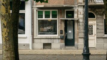 A building with a boutique hotel sign, a door with a window, and a number 32 on the wall.