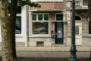Un edificio con un letrero de hotel boutique, una puerta con un ventanal y el número 32 en la pared.