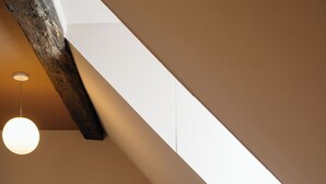 A modern hotel room with a sloped ceiling, a bed, a round table, two chairs, and a sofa. -  Hotel Vrythof - just a room - digital key by email or SMS (Maastricht)