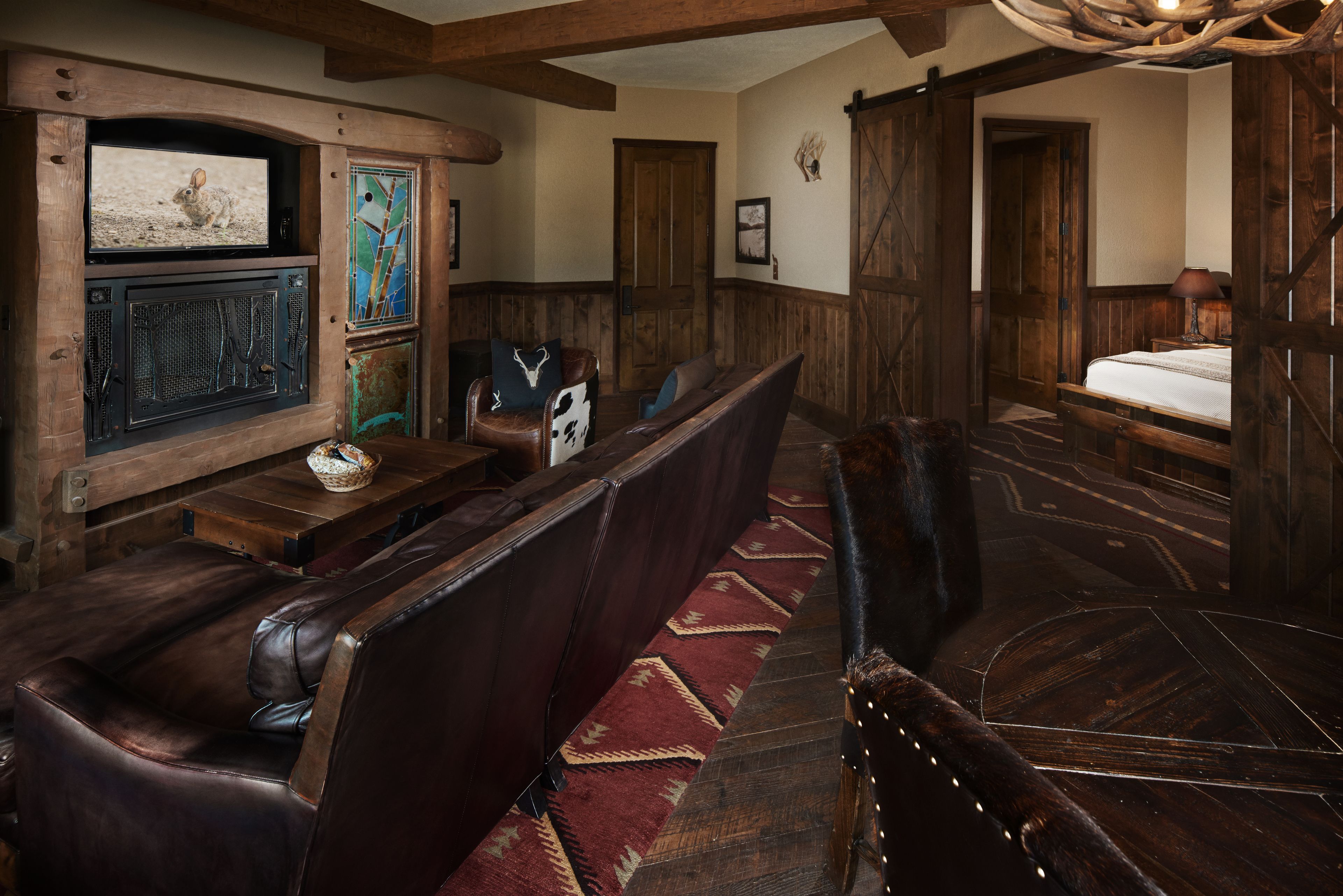 A rustic interior with wooden furniture, a fireplace, and a bed.