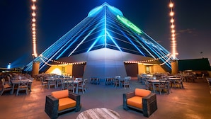 A modern building with a triangular roof, outdoor seating area, and string lights. - Big Cypress Lodge (Memphis)