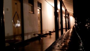 A corridor with a bench, a door, and a wall with a geometric decoration. - Jayasinghe Holiday Resort (Kataragama)