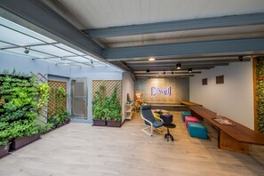 A modern indoor space with a reception desk, seating area, and vertical gardens. - D'well Hostel (Kaohsiung)