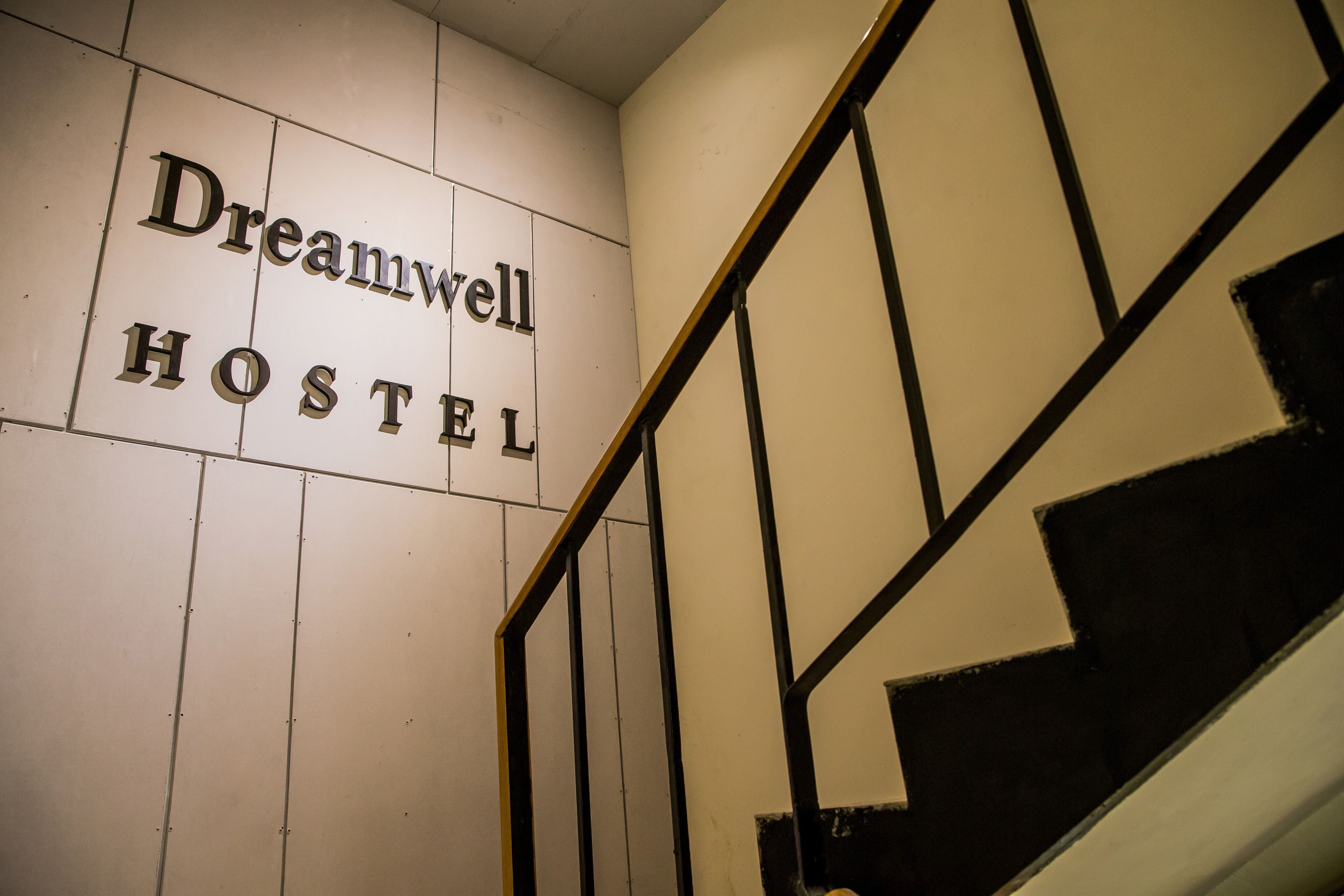 Una escala amb un senyal que diu 'Dreamwell HOSTEL'.