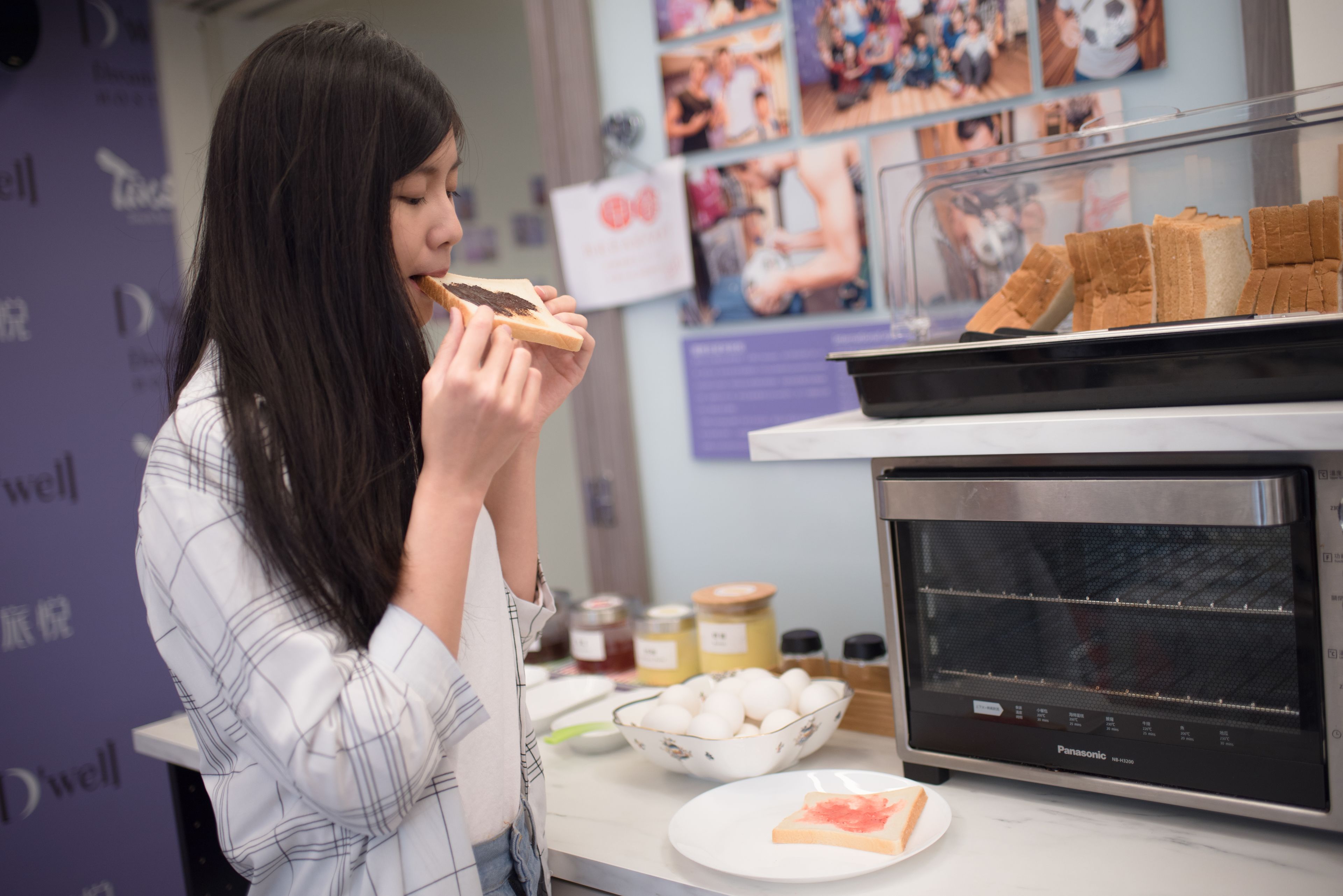 Eine Person hält eine Brotscheibe neben einem Panasonic-Ofen.
