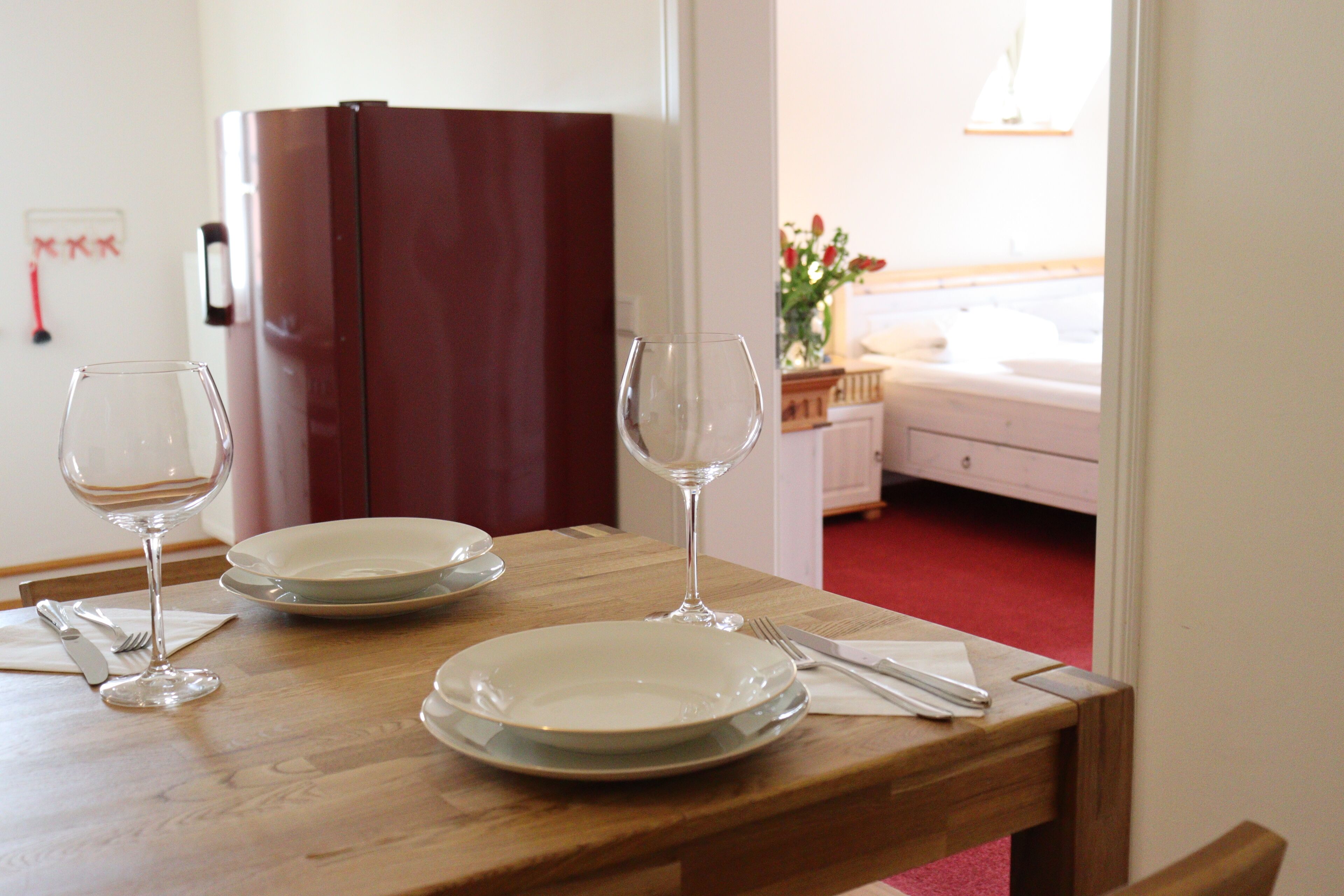 A dining table set with plates, wine glasses, and cutlery.
