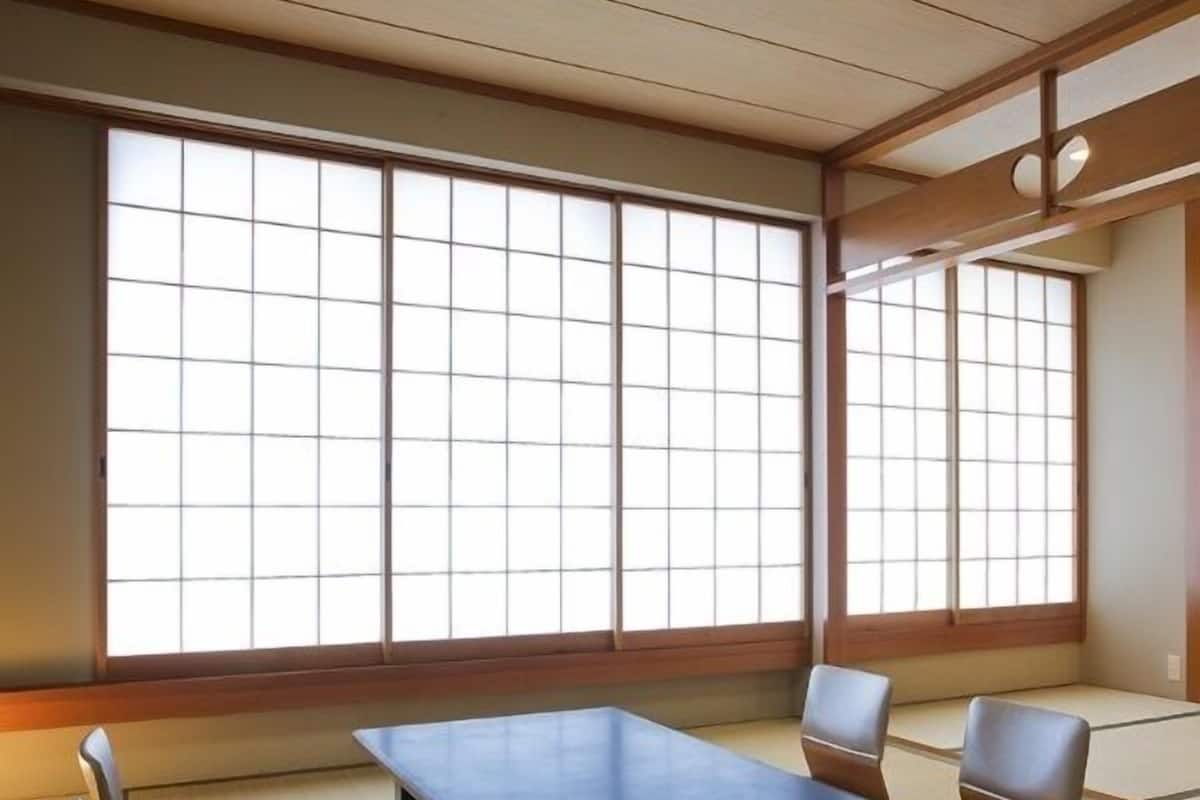 Una habitación japonesa tradicional con suelo de tatami, una mesa baja y cojines.