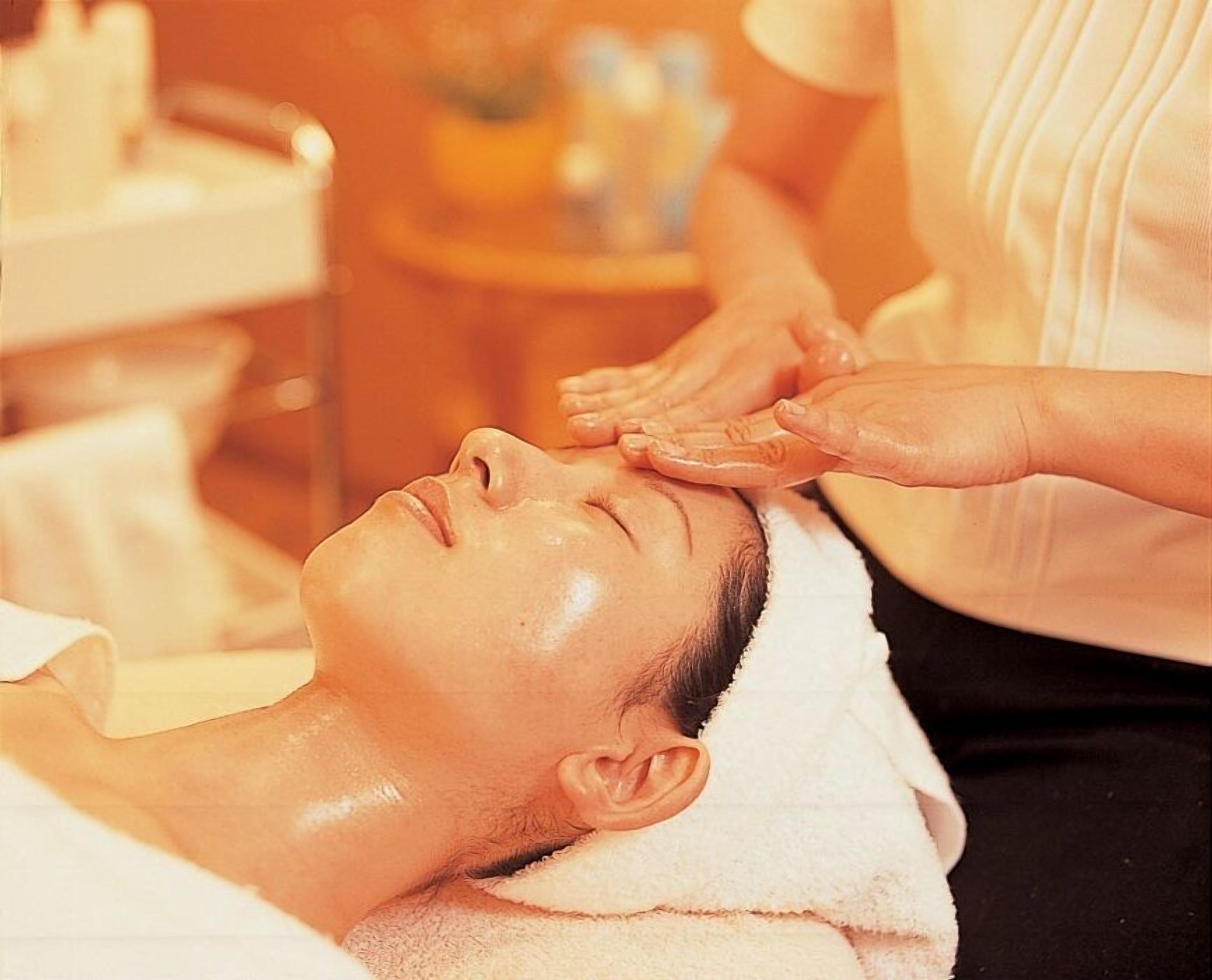 A person receiving a facial treatment in a spa setting.