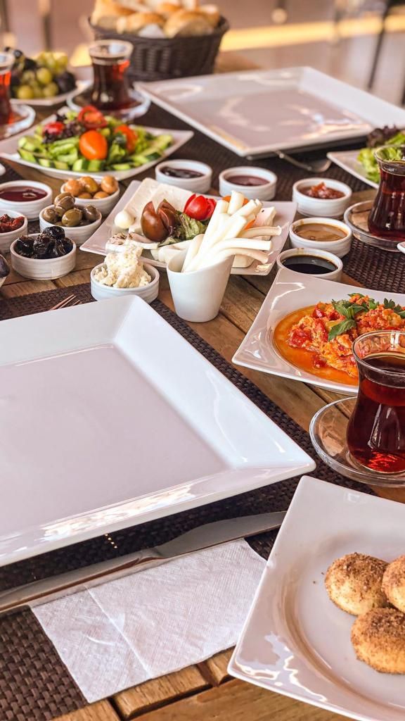 A table set with various dishes, including salads, cheeses, and bread, suggesting a meal setting.