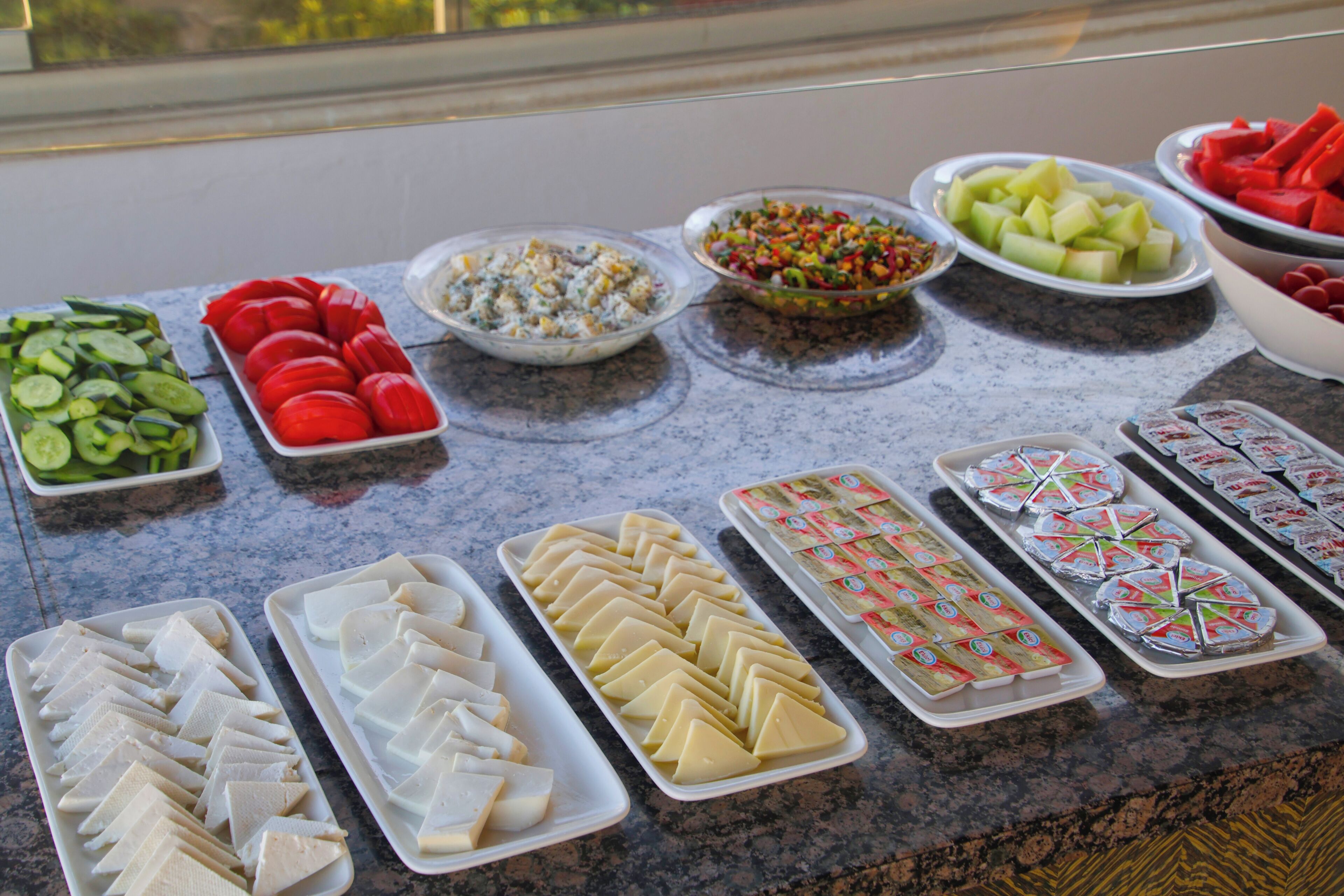 A buffet table with various food items.