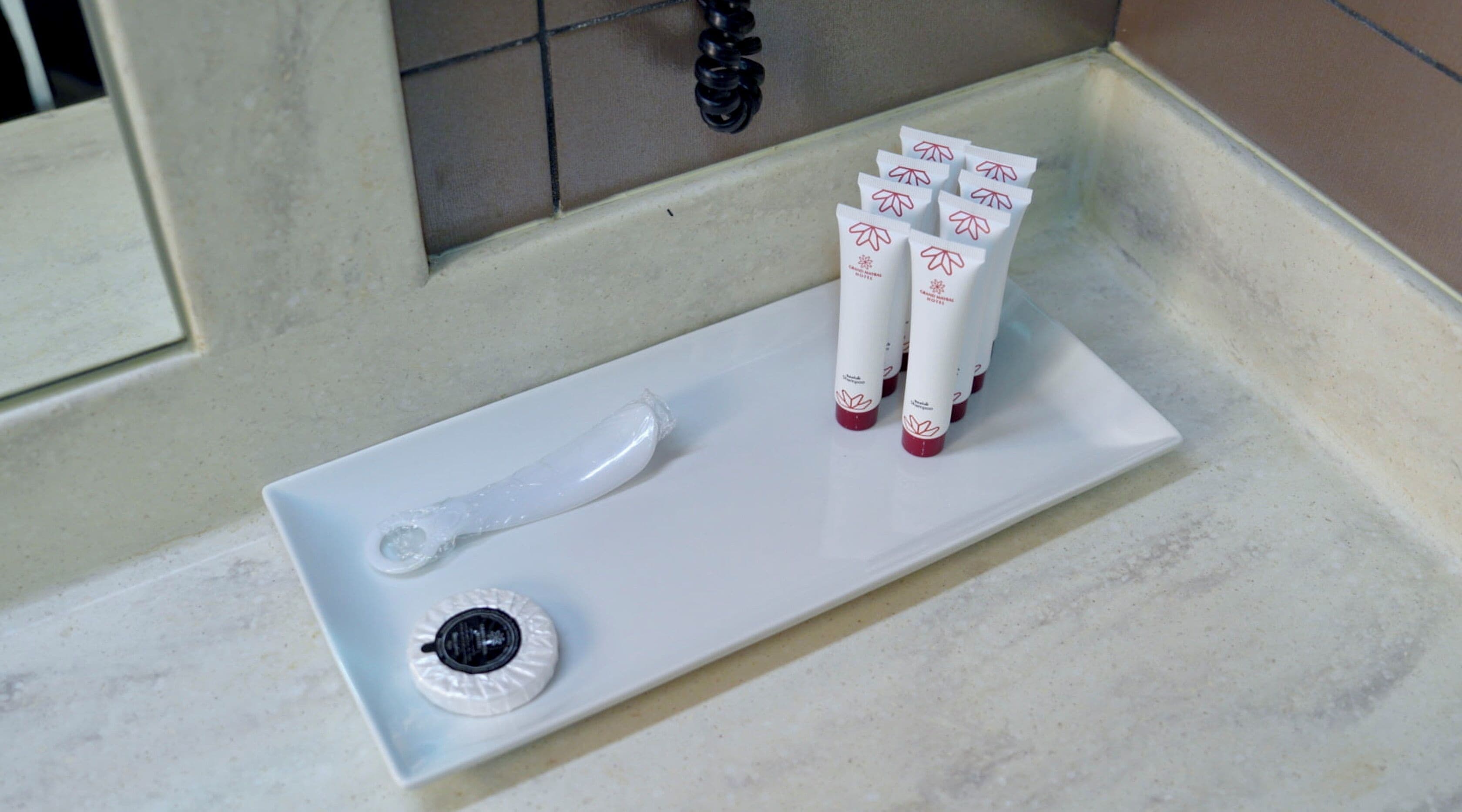 Un lavamanos de baño con un lavabo blanco, un grifo y un dispensador de jabón.