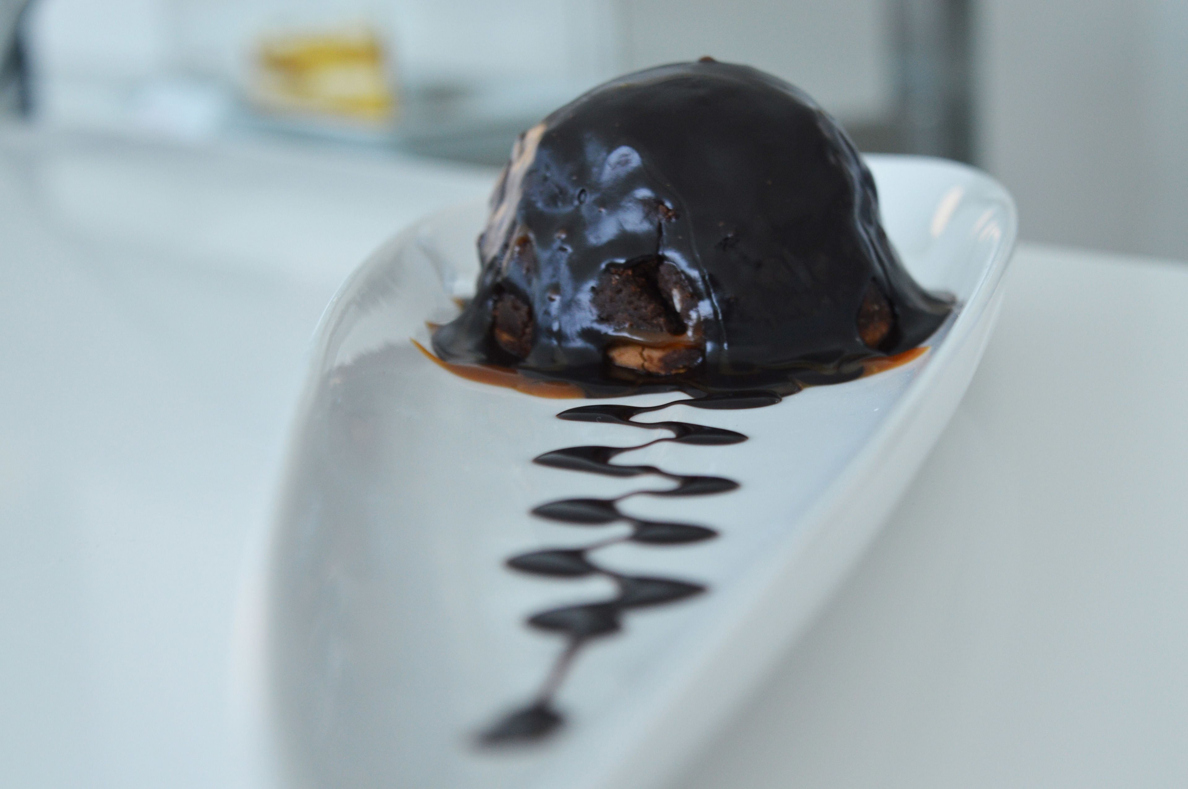 A dessert on a white plate with chocolate sauce.