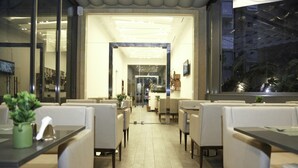 Un restaurante moderno con un interior limpio y minimalista, con mobiliario blanco y un ambiente luminoso y acogedor.