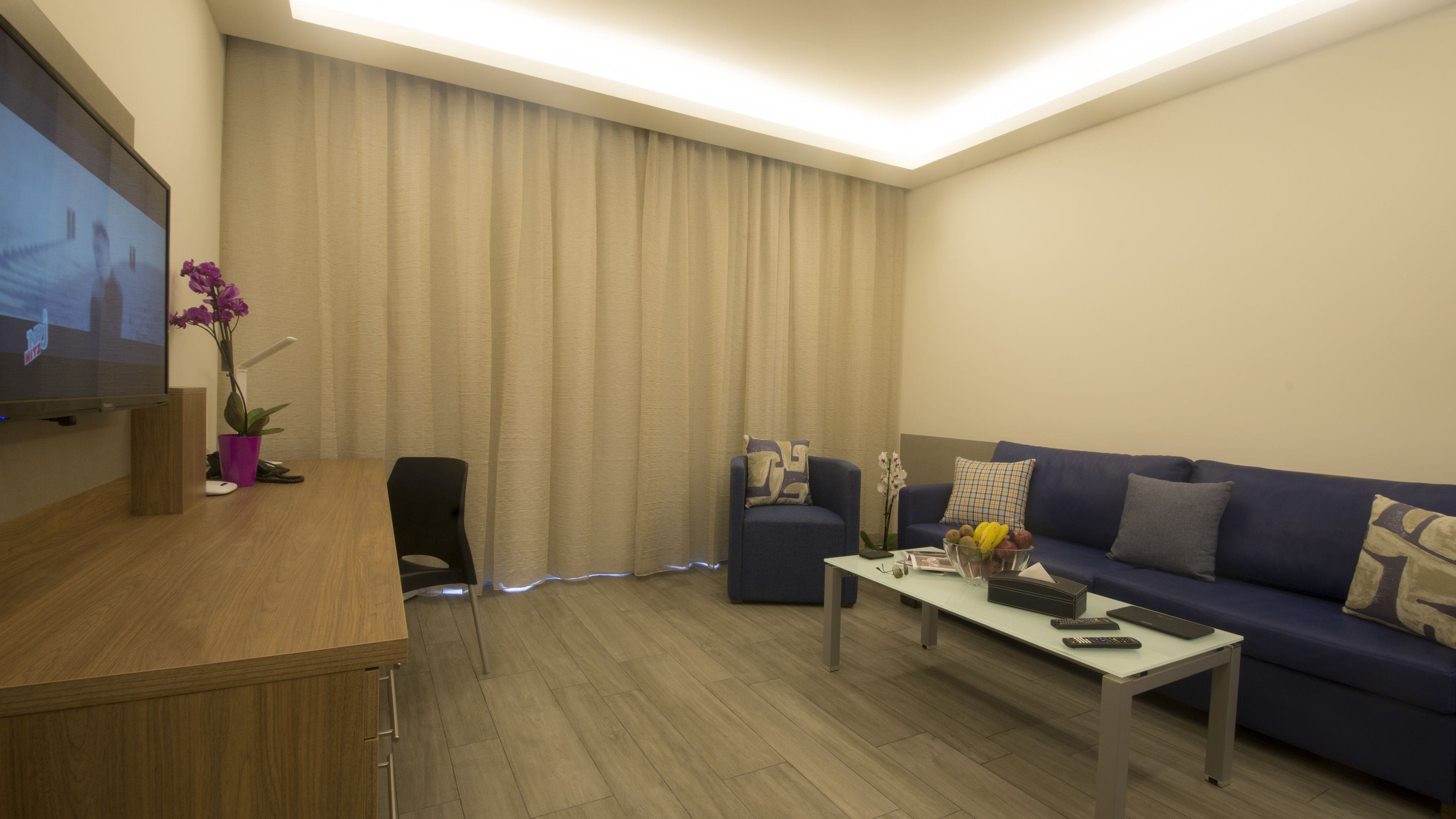 deluxe one bedroom suite, with balcony | living area | 40-inch led tv with satellite channels, tv, fireplace