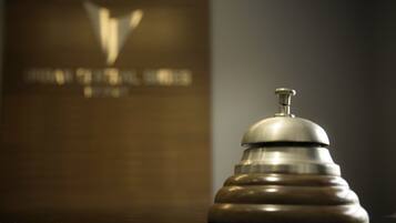 A salt and pepper shaker on a reflective surface with a blurred background featuring a logo and text.