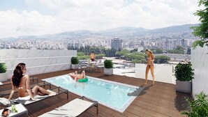 Un área de piscina en la azotea con vistas a la ciudad, sillas de descanso y plantas en macetas.