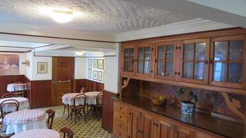 A dining area with wooden cabinets, a patterned floor, and a ceiling with a textured finish.