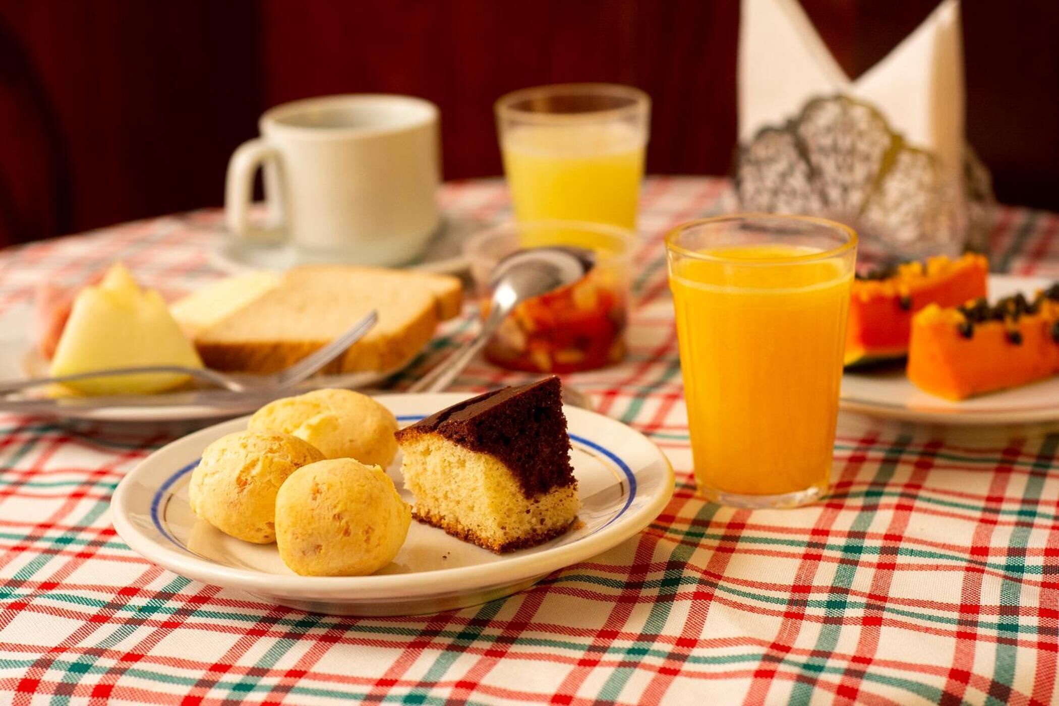 A breakfast setting with a plate of food, a glass of orange juice, and a cup.