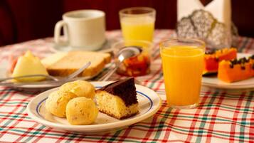 A breakfast setting with a plate of food, a glass of orange juice, and a cup.