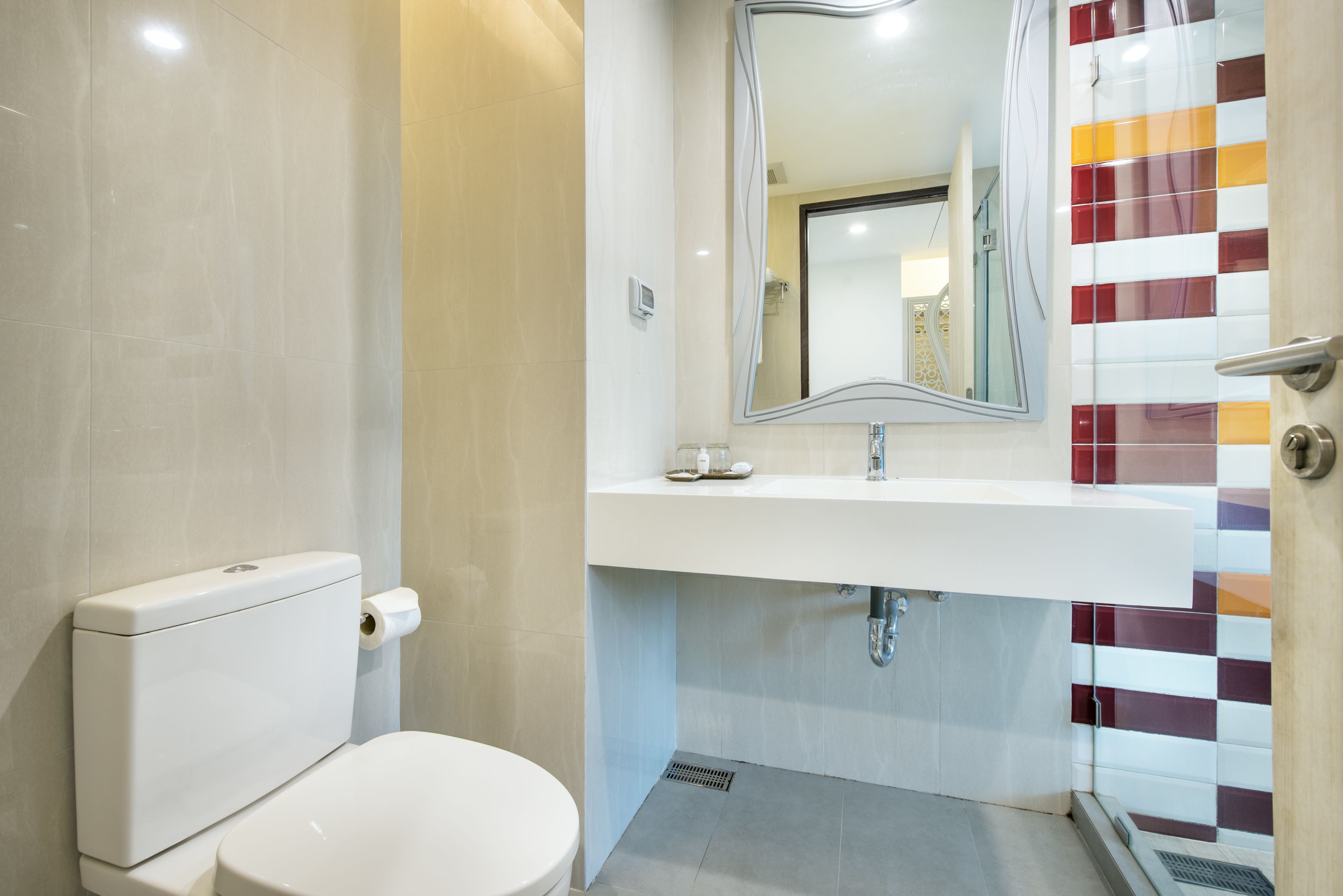 A modern bathroom with a toilet, sink, and shower.