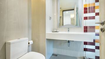 A modern bathroom with a toilet, sink, and shower.