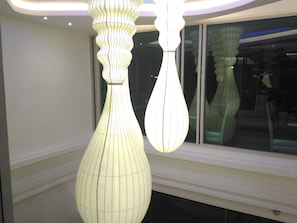 Dos lámparas colgantes blancas con diseño acanalado, iluminadas, suspendidas del techo.