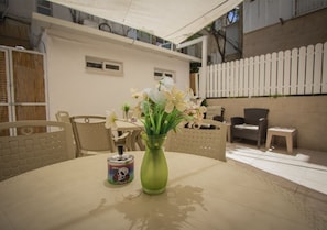 A round table with a green vase of flowers and a can of soda. - Apartment - Tel Aviv (Tel Aviv)