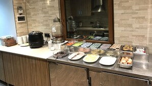 A buffet setup with various food items and a honey dispenser. - Nur Hotel (Trabzon)