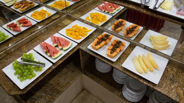 Un buffet proposant une variété de fruits et de légumes disposés sur des assiettes blanches.