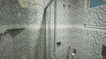 A bathroom with a shower, toilet, and tiled walls.