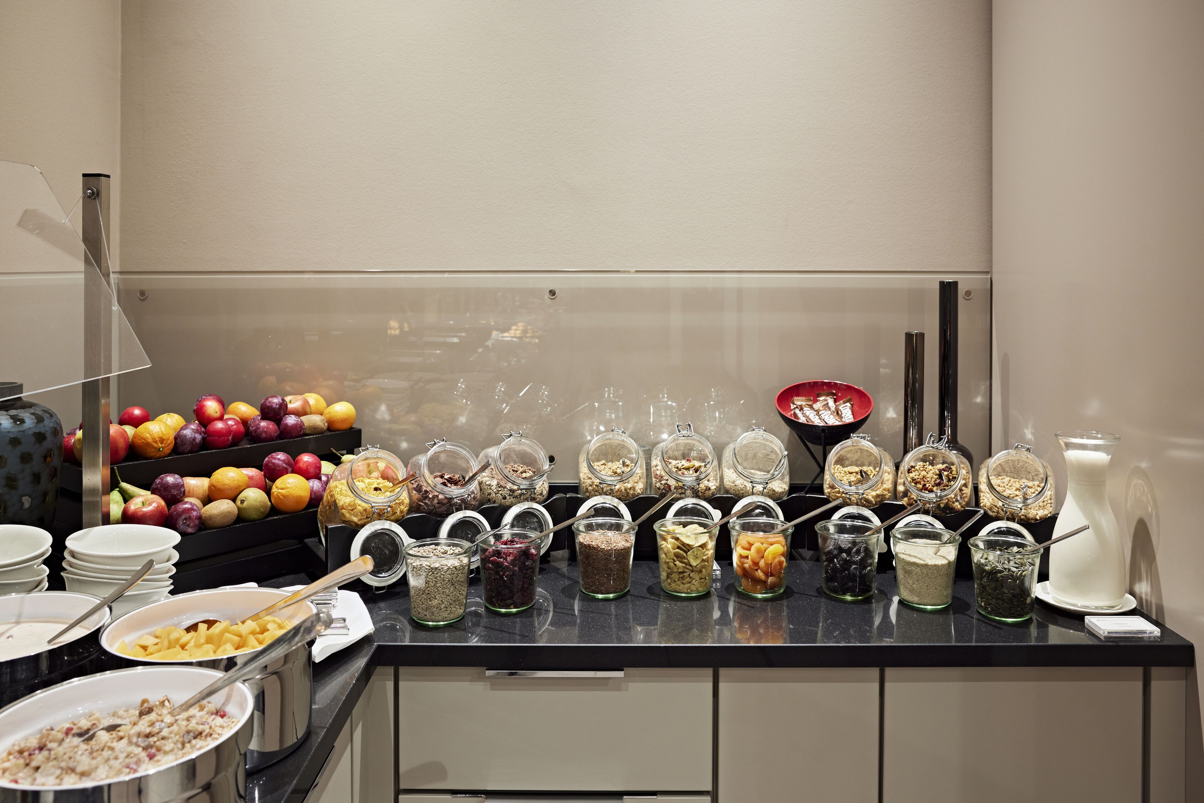 A buffet with various food items and fruits.