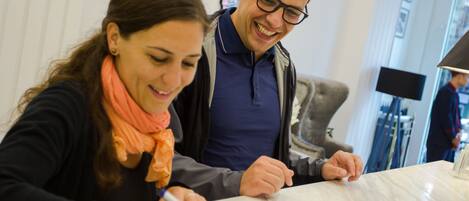 Two people signing a document at a table with a white marble top.