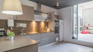 Una cocina moderna con una isla grande, electrodomésticos de acero inoxidable y vistas a la terraza exterior.