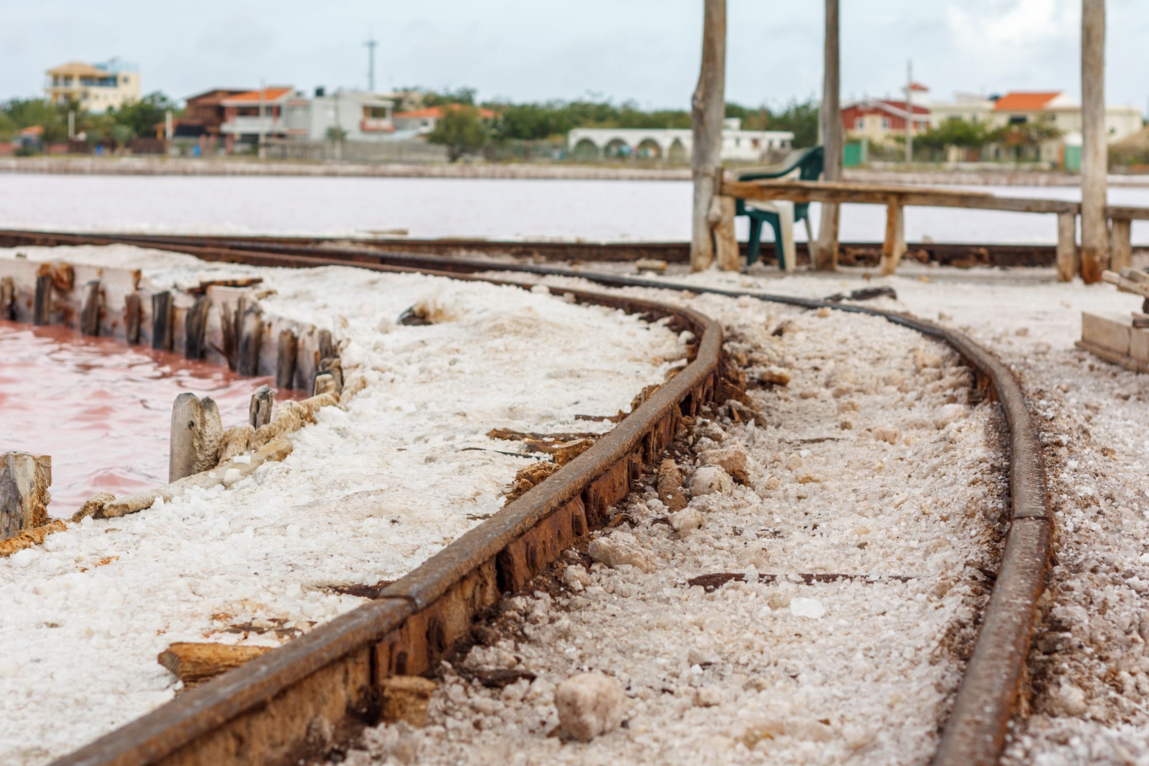A salt flat with a wooden walkway curving through it.