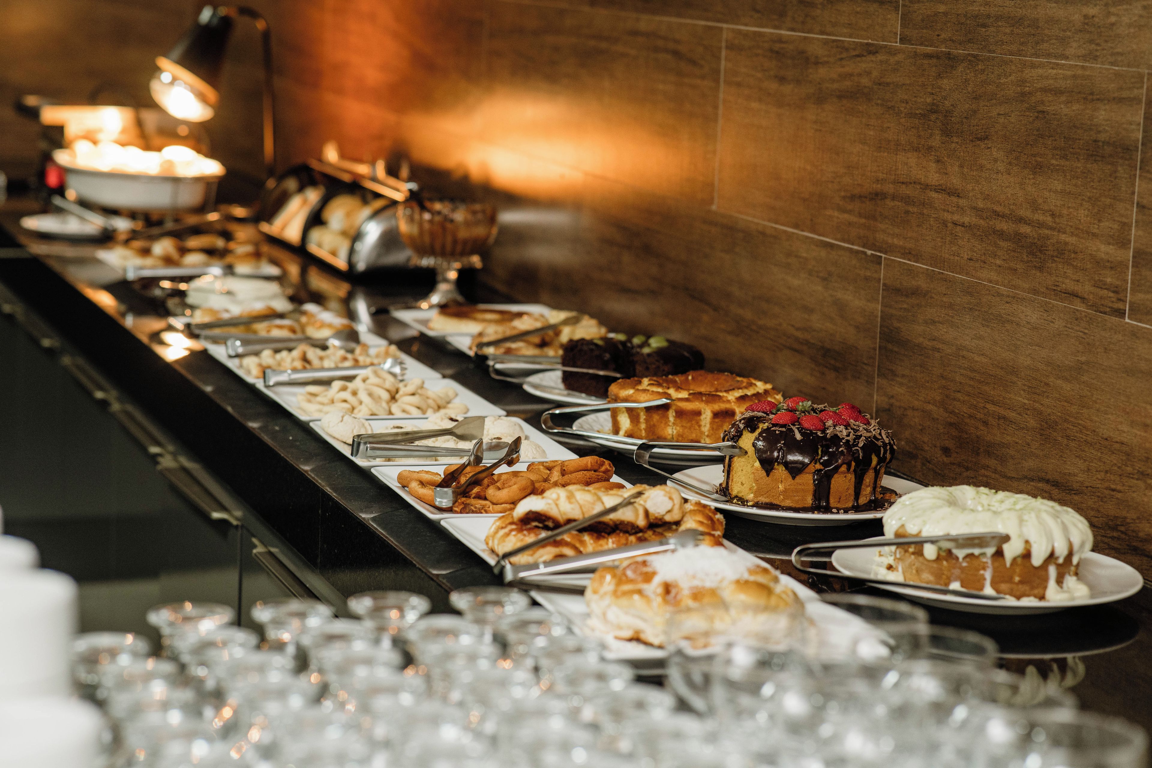 Buffet-pöytä, jossa on tarjolla monenlaista ruokaa ja ruokailuvälineitä.