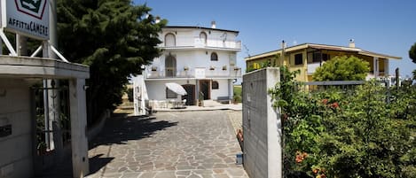 A stone-paved entrance to a building with a sign indicating a camera rental service.